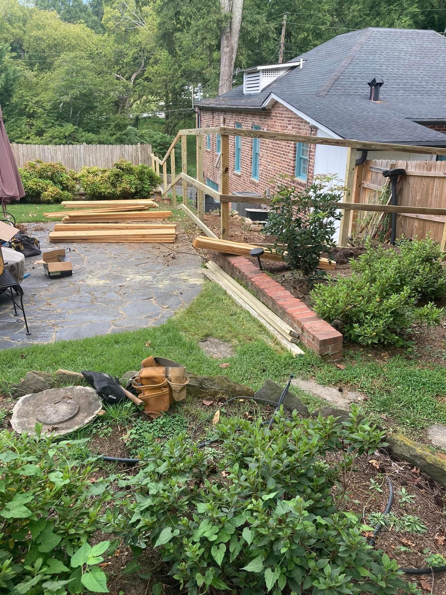 A wooden fence is being built in the backyard of a house.