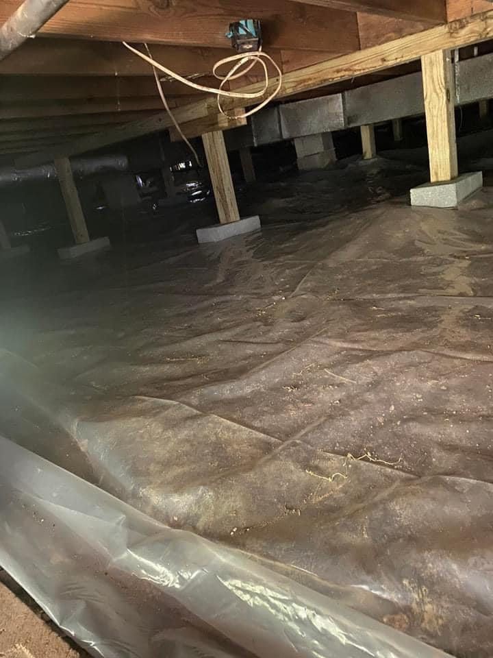 A basement with a lot of plastic covering the floor.