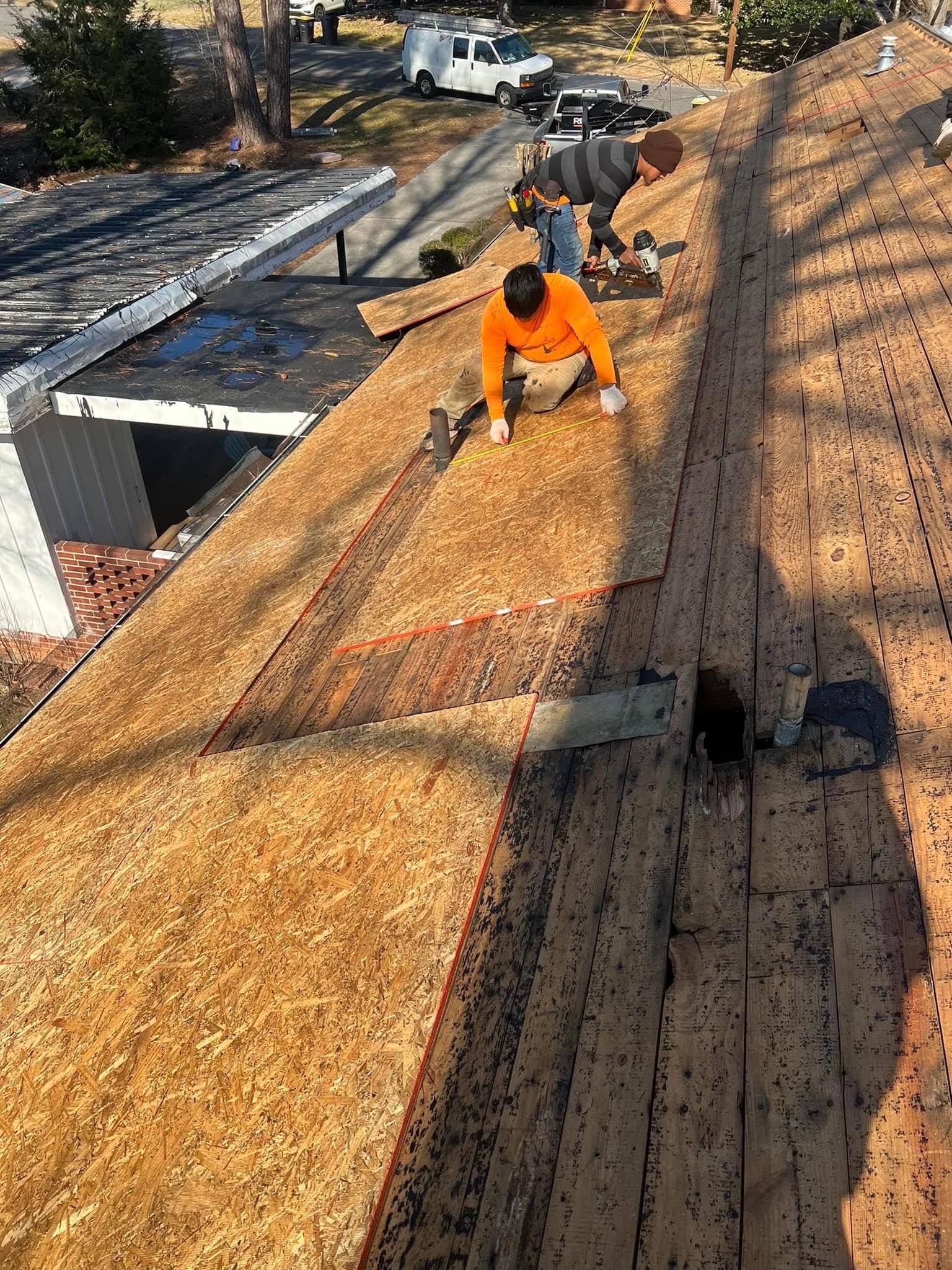 A man is working on the roof of a house.