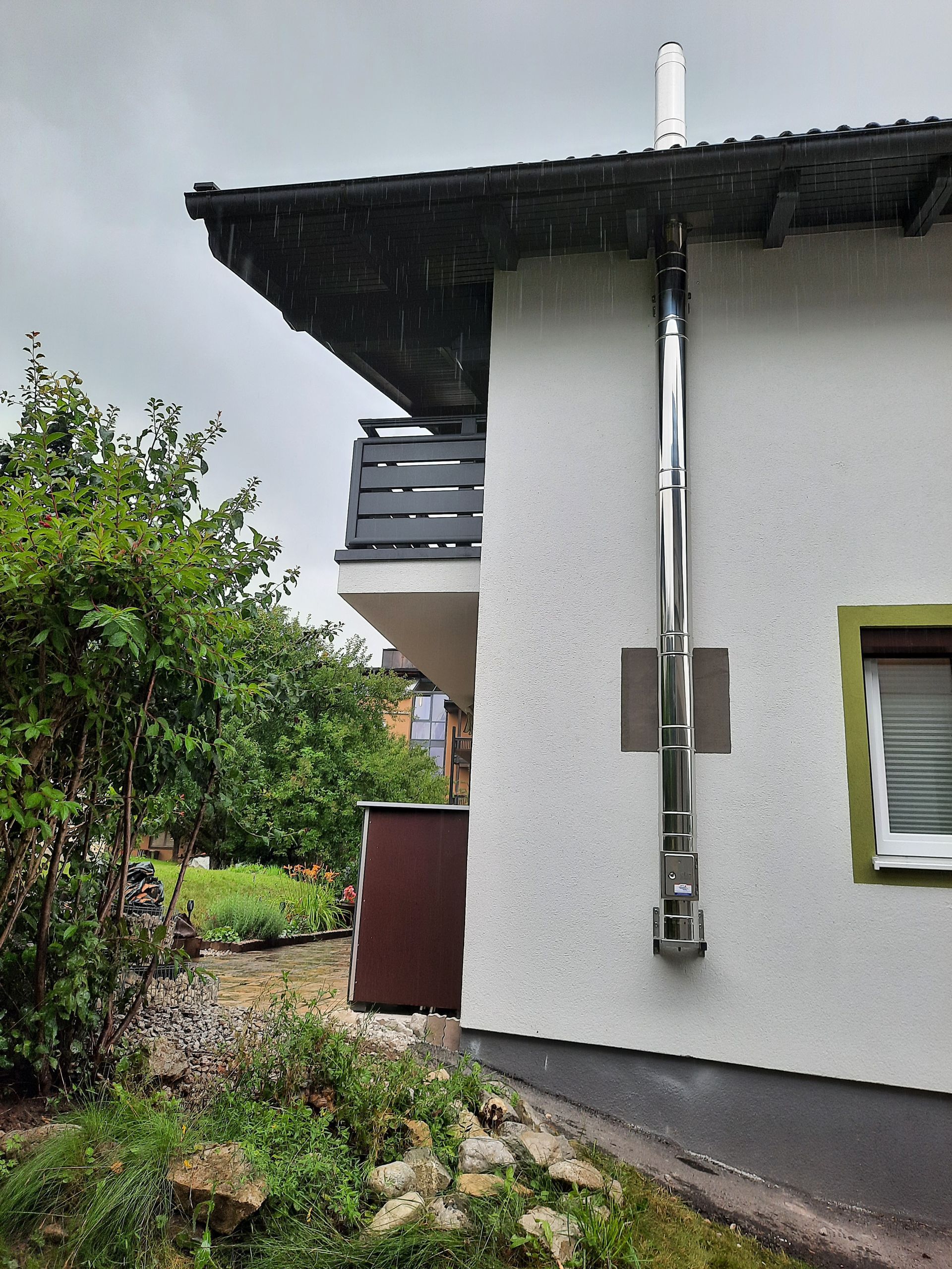 Ein weißes Haus mit einem Schornstein an der Seite