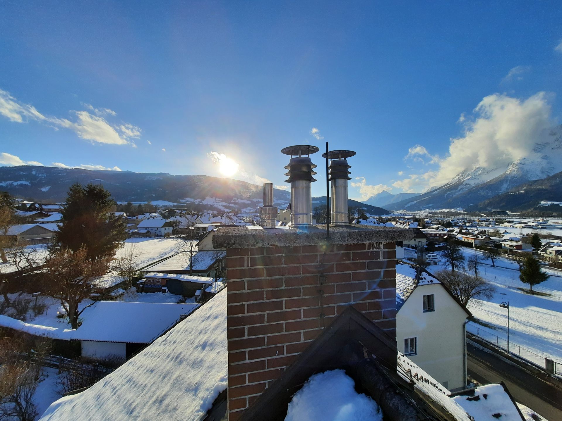 Ein schneebedecktes Dach mit einem Schornstein darauf