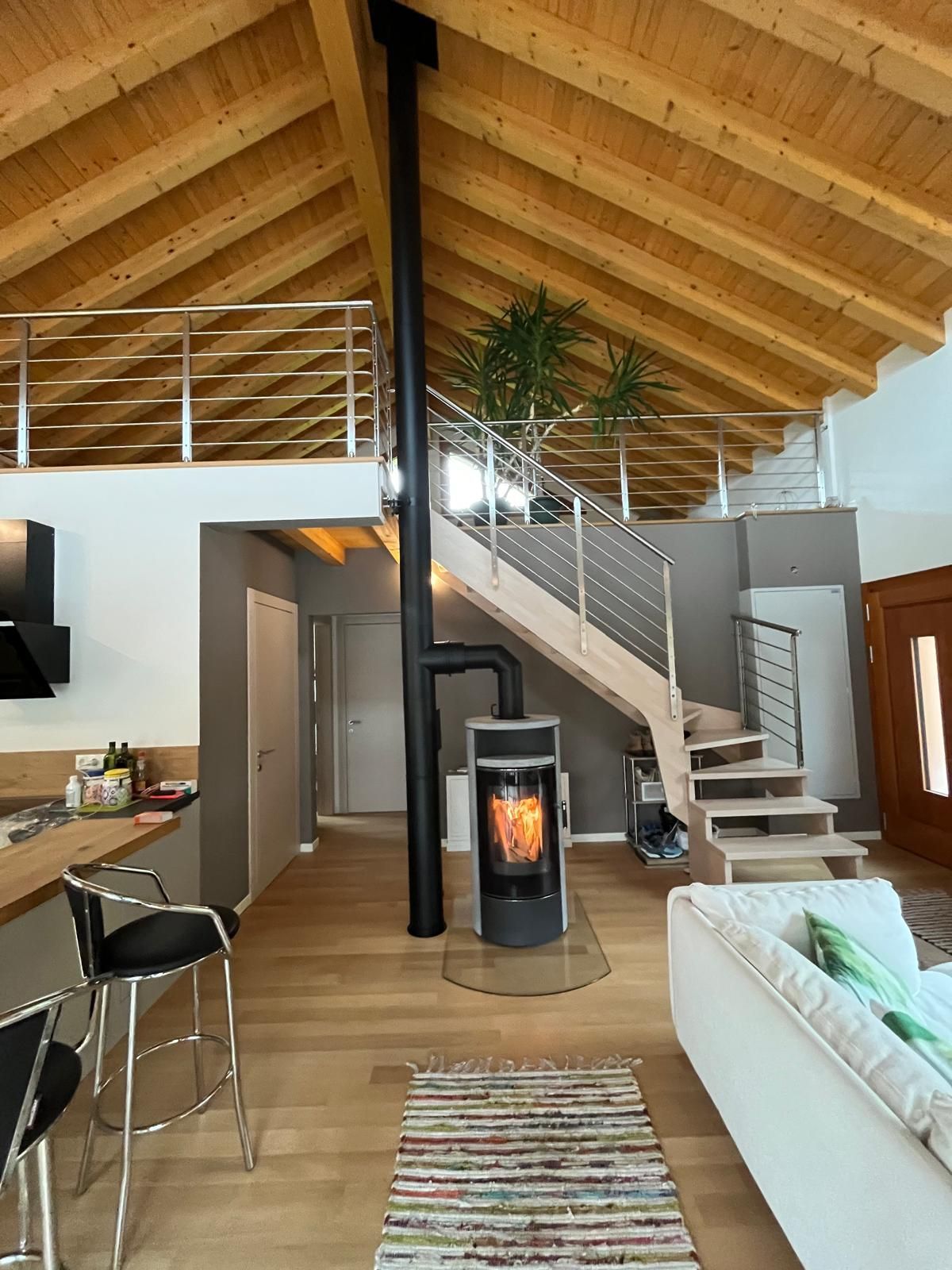 Ein Wohnzimmer mit Holzofen und Treppe