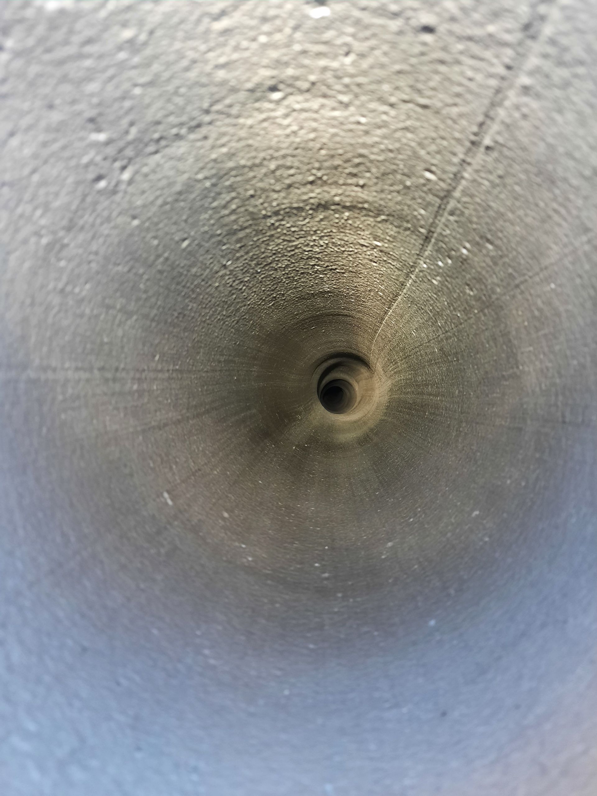Eine Nahaufnahme eines Metallrohrs mit einem Loch in der Mitte.