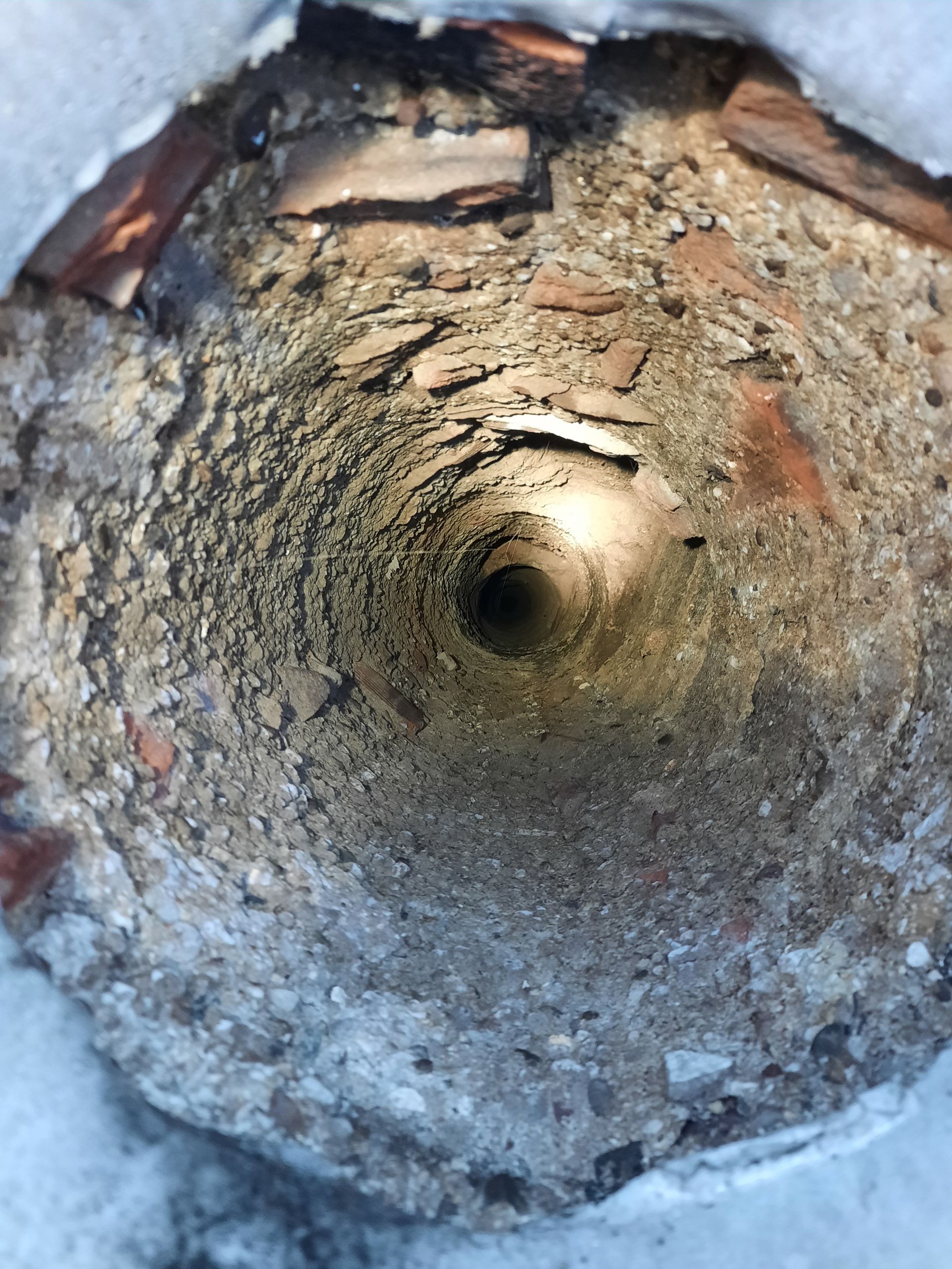 Eine Nahaufnahme eines Lochs im Boden, aus dem ein Licht kommt.