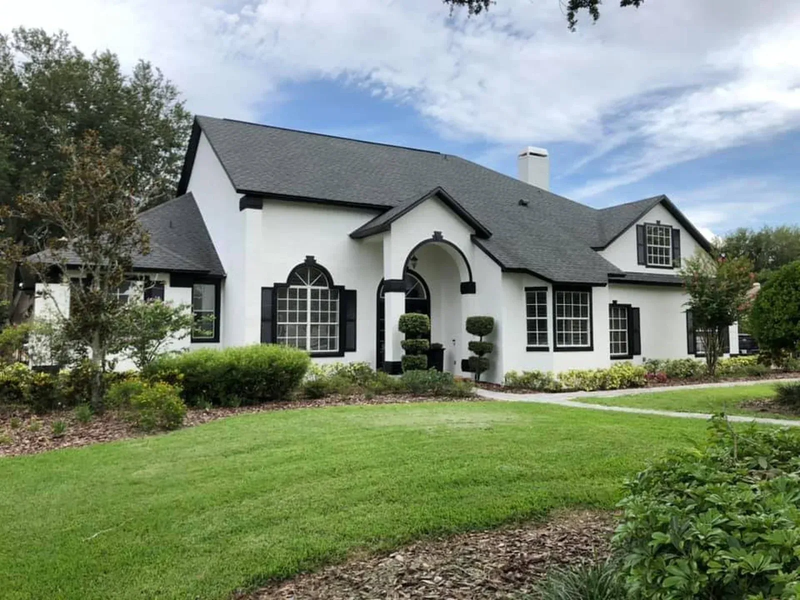 A large white house with a black roof and black shutters
