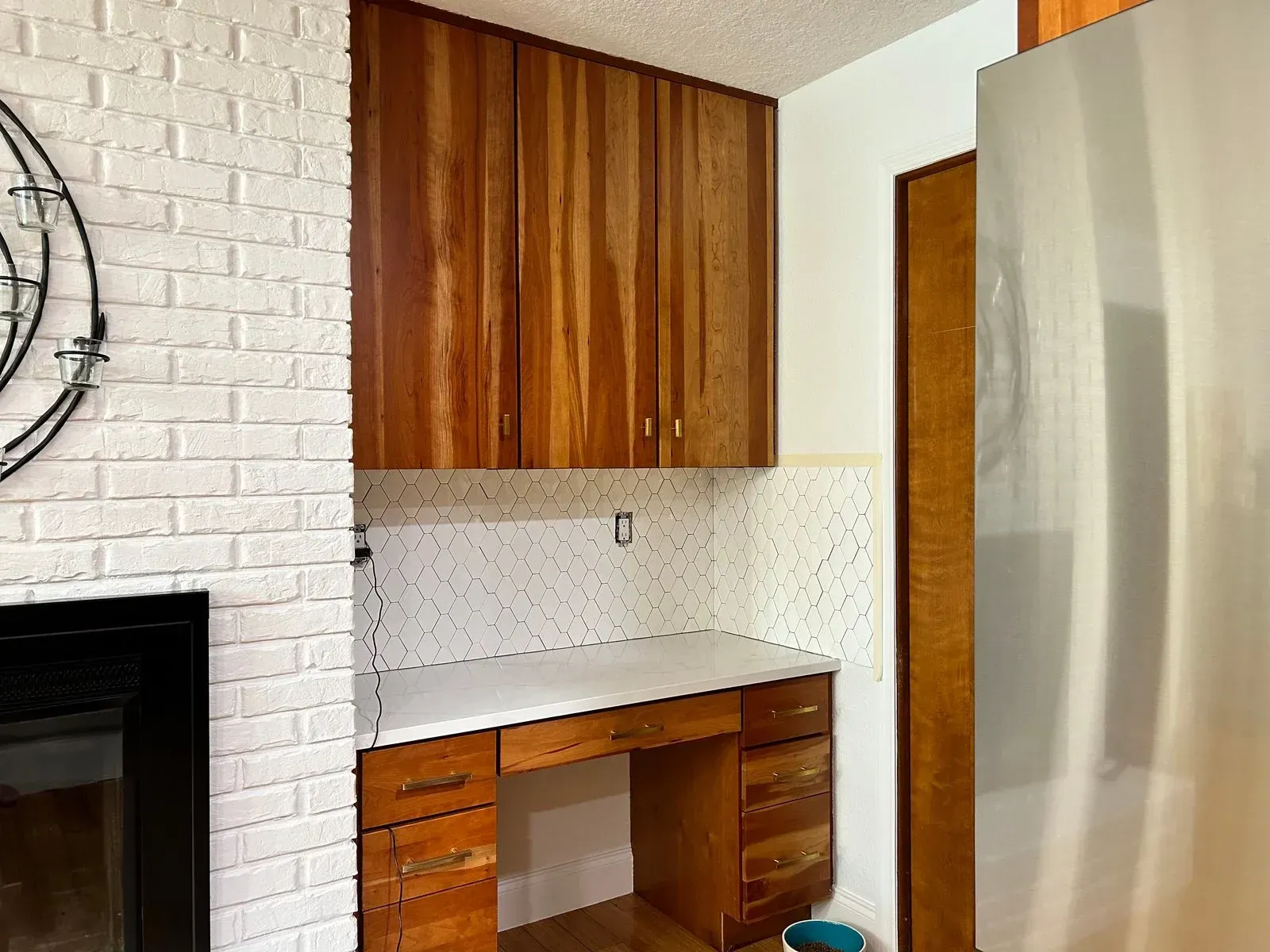 A kitchen with wooden cabinets and a stainless steel refrigerator