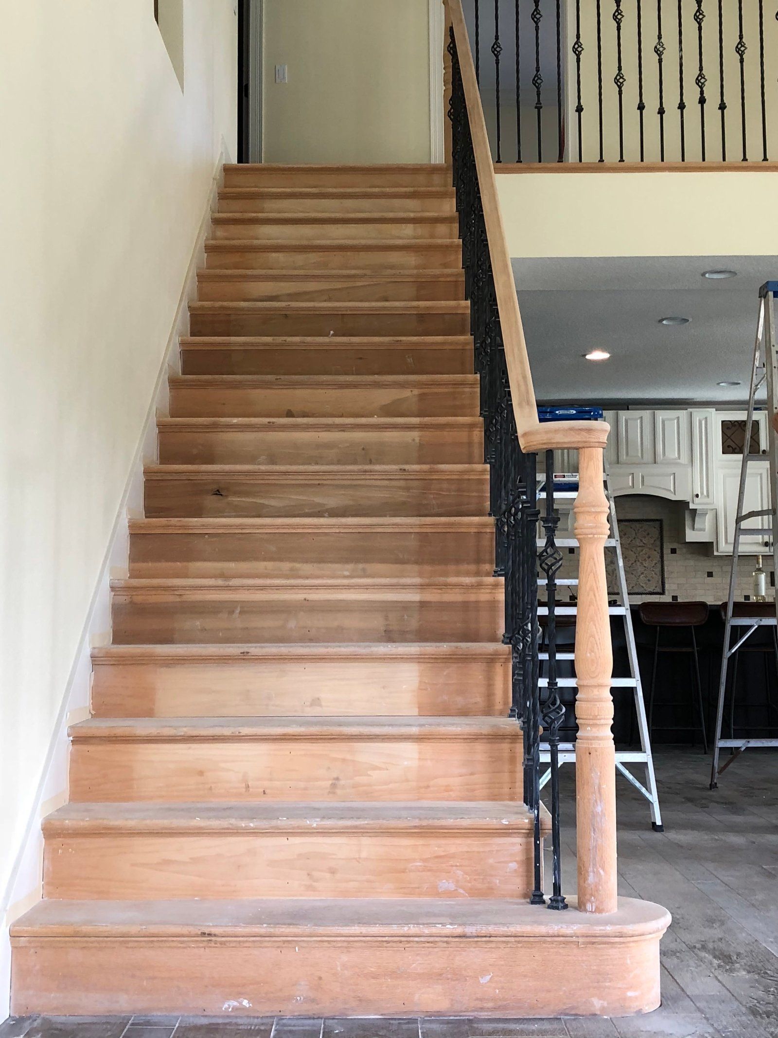 A wooden staircase with a wrought iron railing