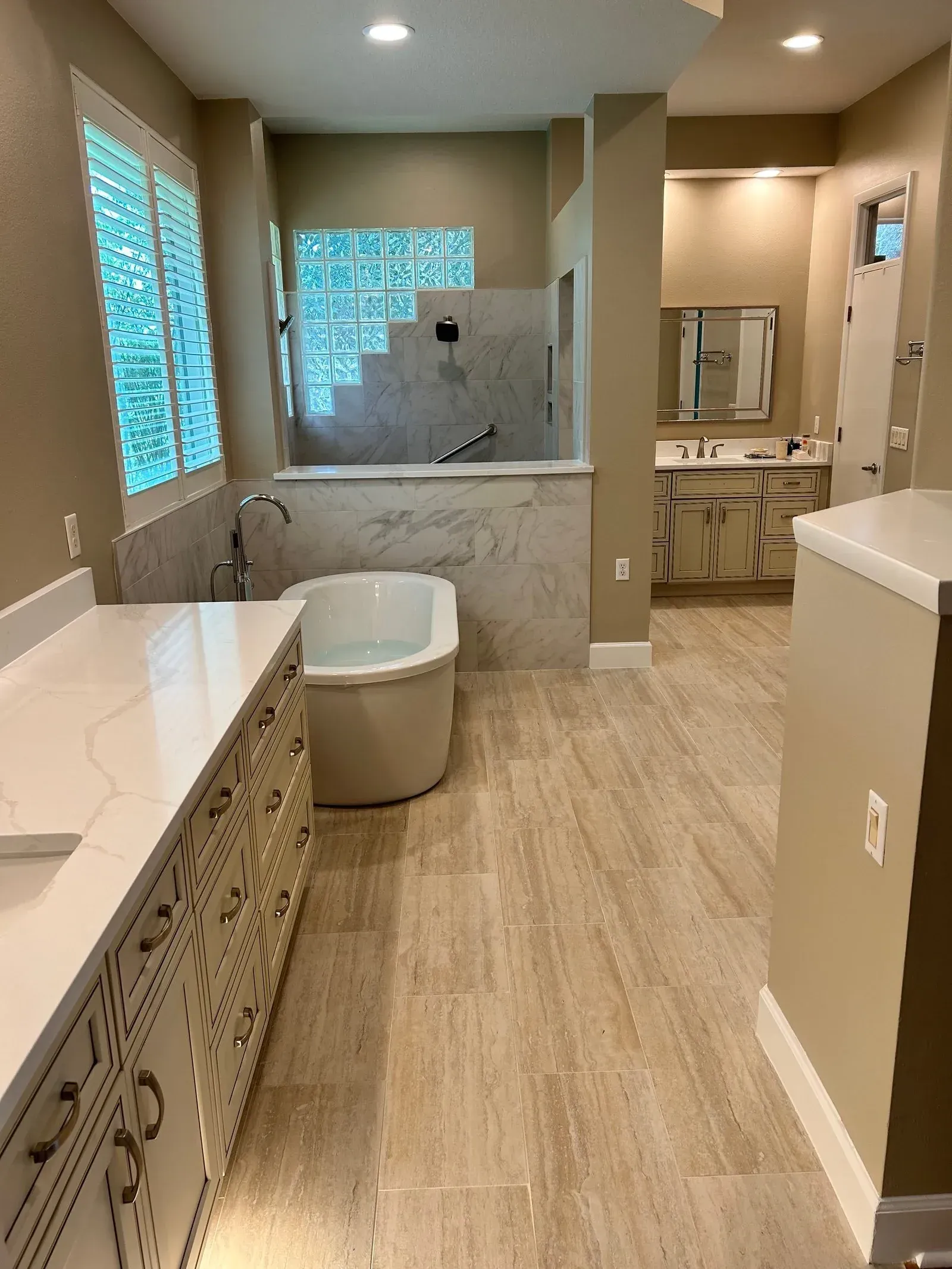A bathroom with a tub , sink , and mirror.