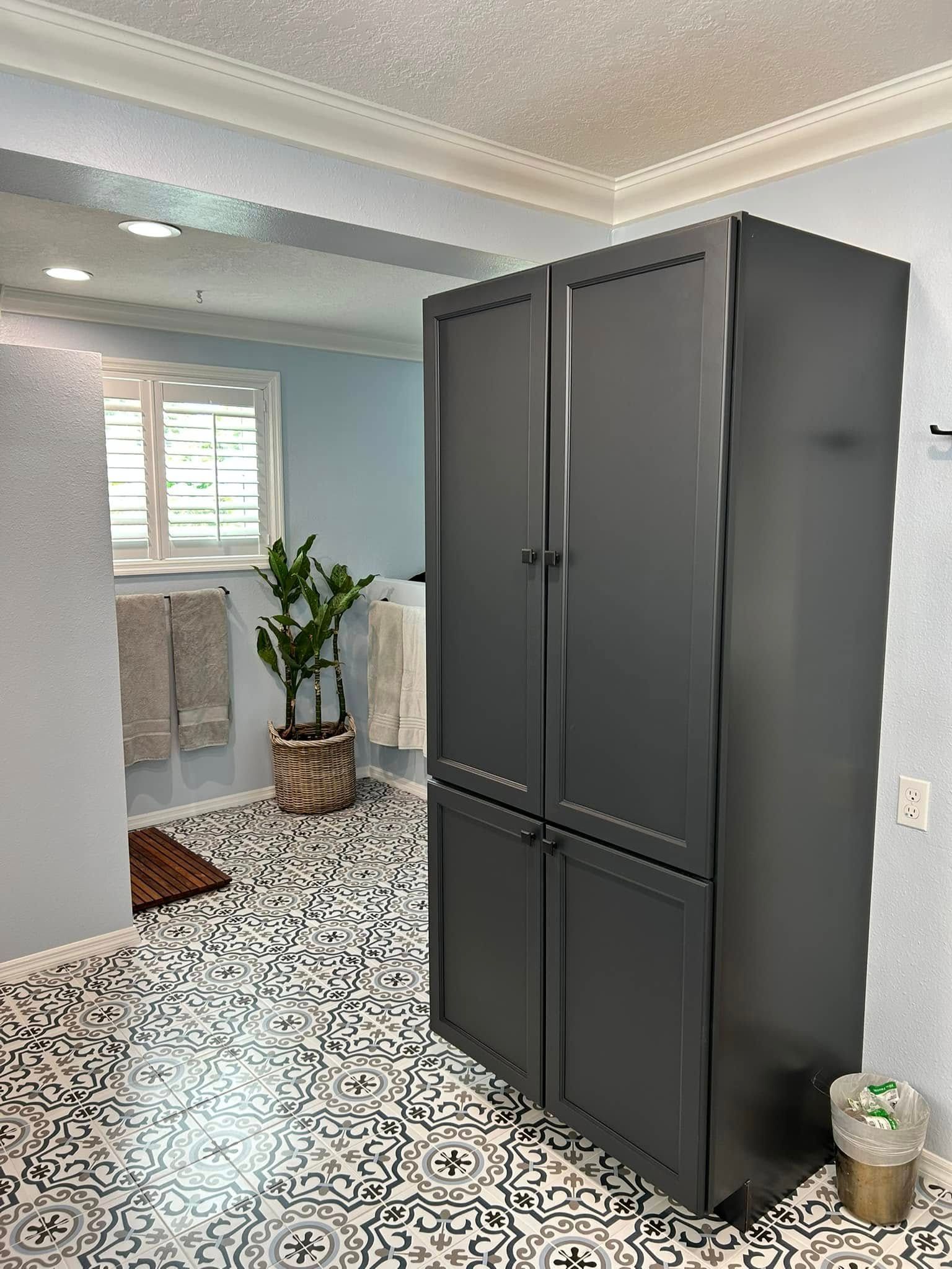 A bathroom with a black cabinet and a black and white tile floor.
