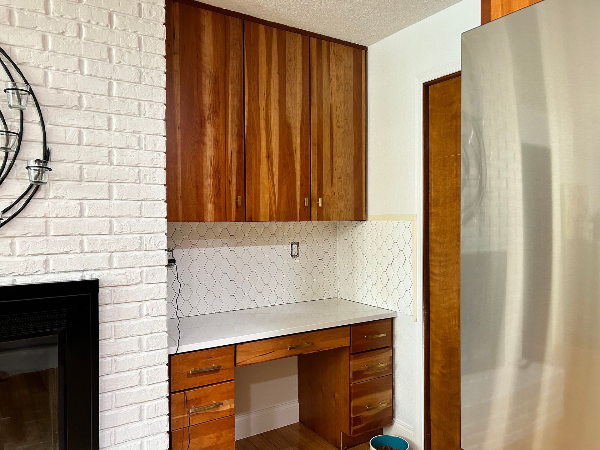 A kitchen with wooden cabinets and a stainless steel refrigerator