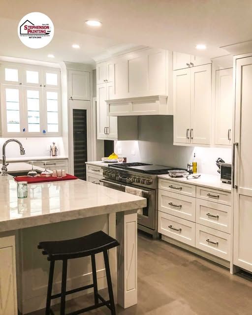 A kitchen with white cabinets and stainless steel appliances