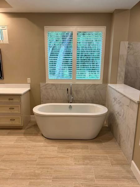 A bathroom with a bathtub and a window