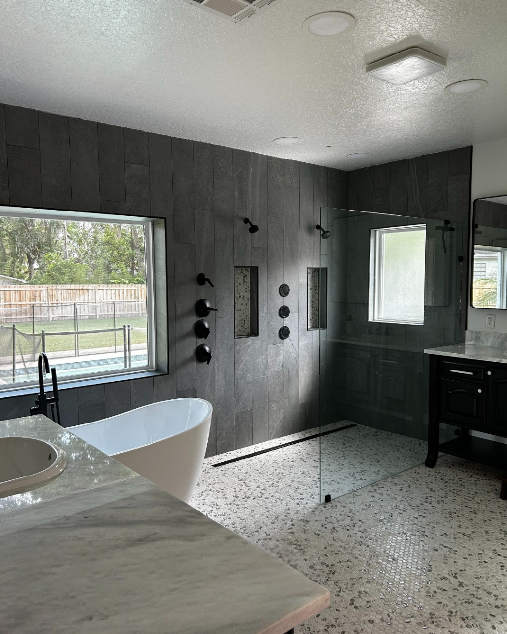 A bathroom with a tub , sink , and shower.