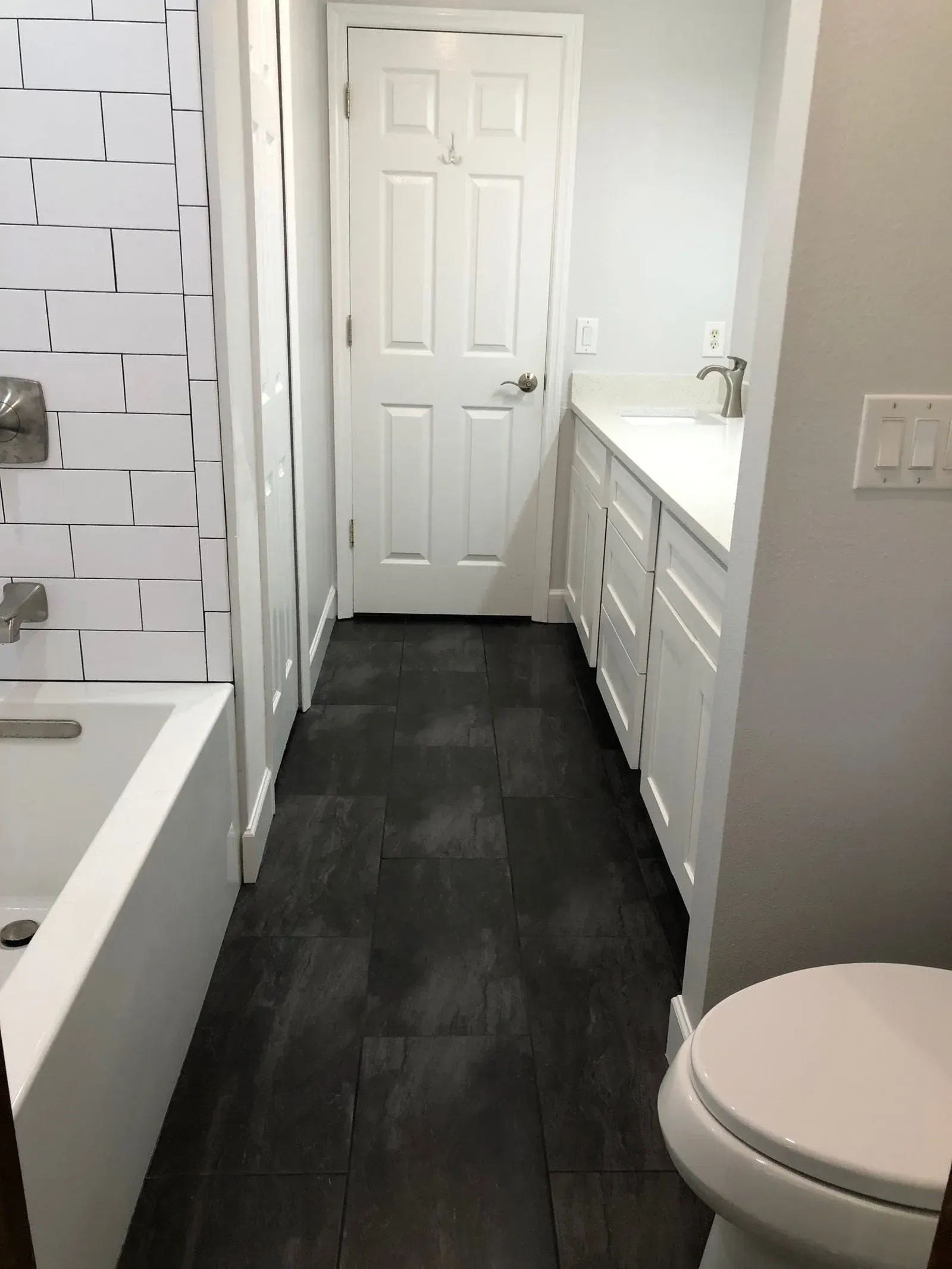 A bathroom with a tub , toilet and sink.