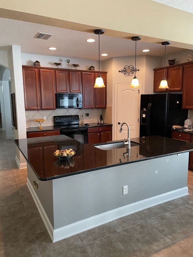 A kitchen with granite counter tops and wooden cabinets