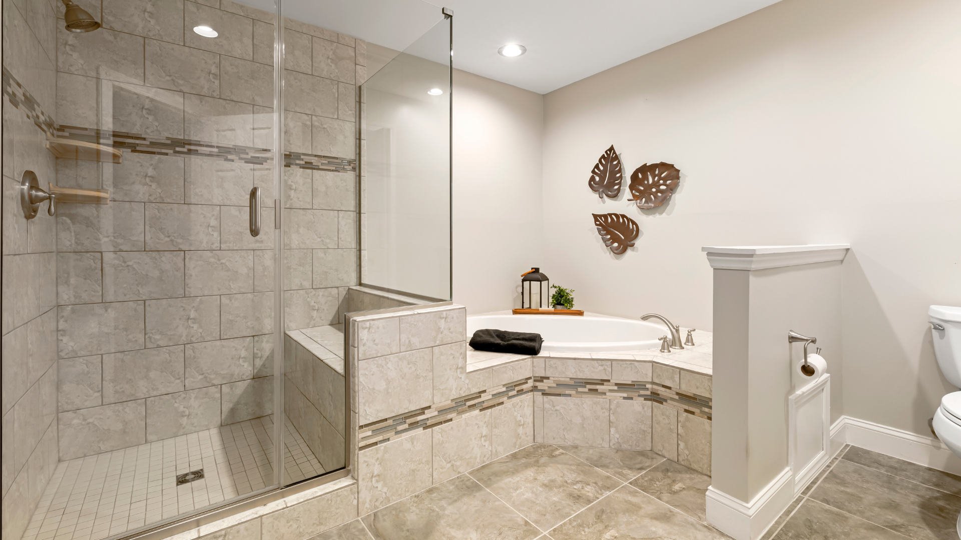 A bathroom with a walk in shower , tub and toilet.