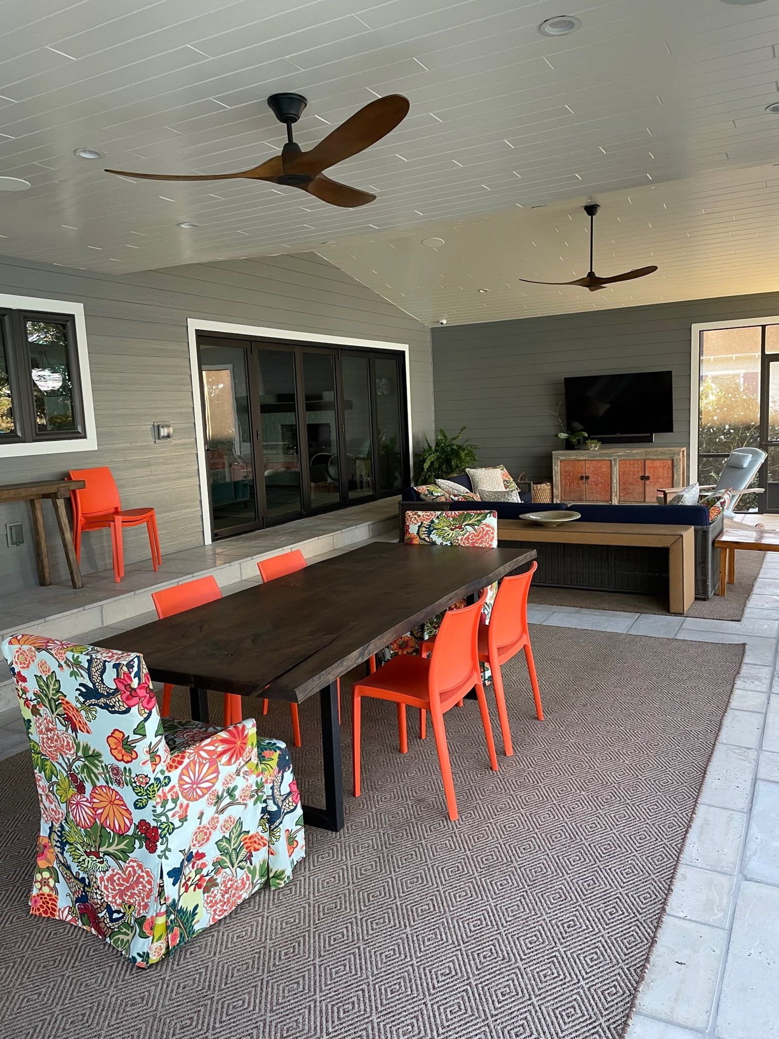 A large room with a table and chairs and a ceiling fan.