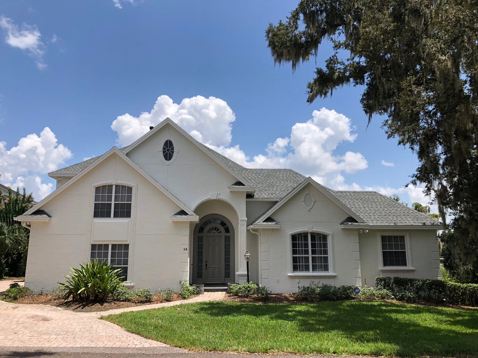 A large white house with a lot of windows and a tree in front of it.
