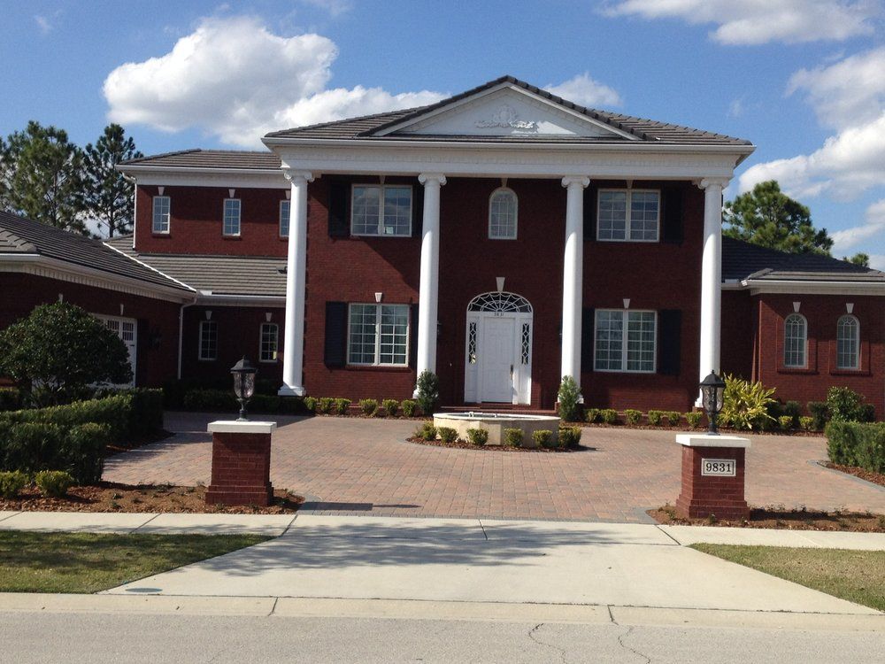 A large red brick house with white columns and shutters