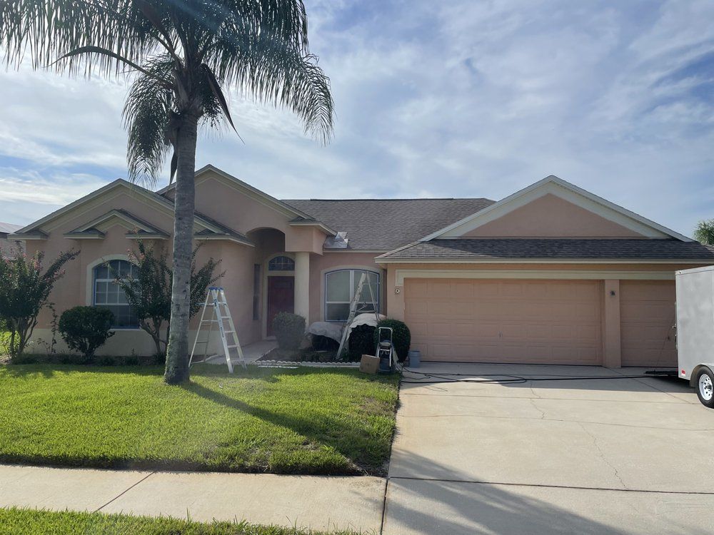 A pink house with a white truck parked in front of it.