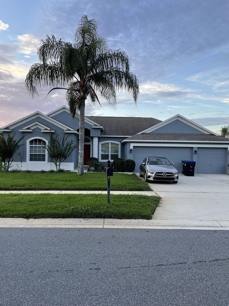 A blue house with a car parked in front of it.