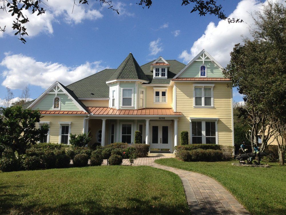 A large yellow house with a green roof