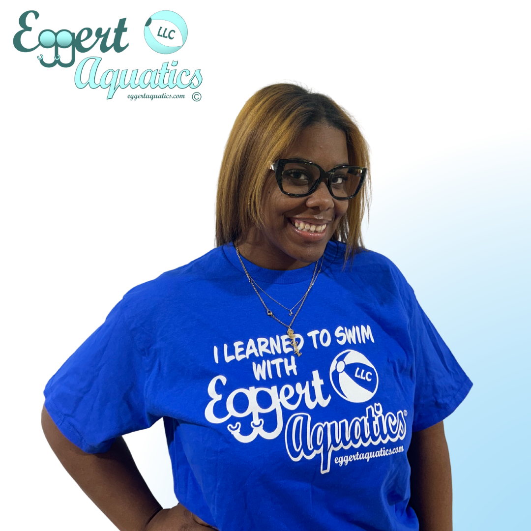 A man wearing a blue shirt that says i learned to swim with expert aquatics