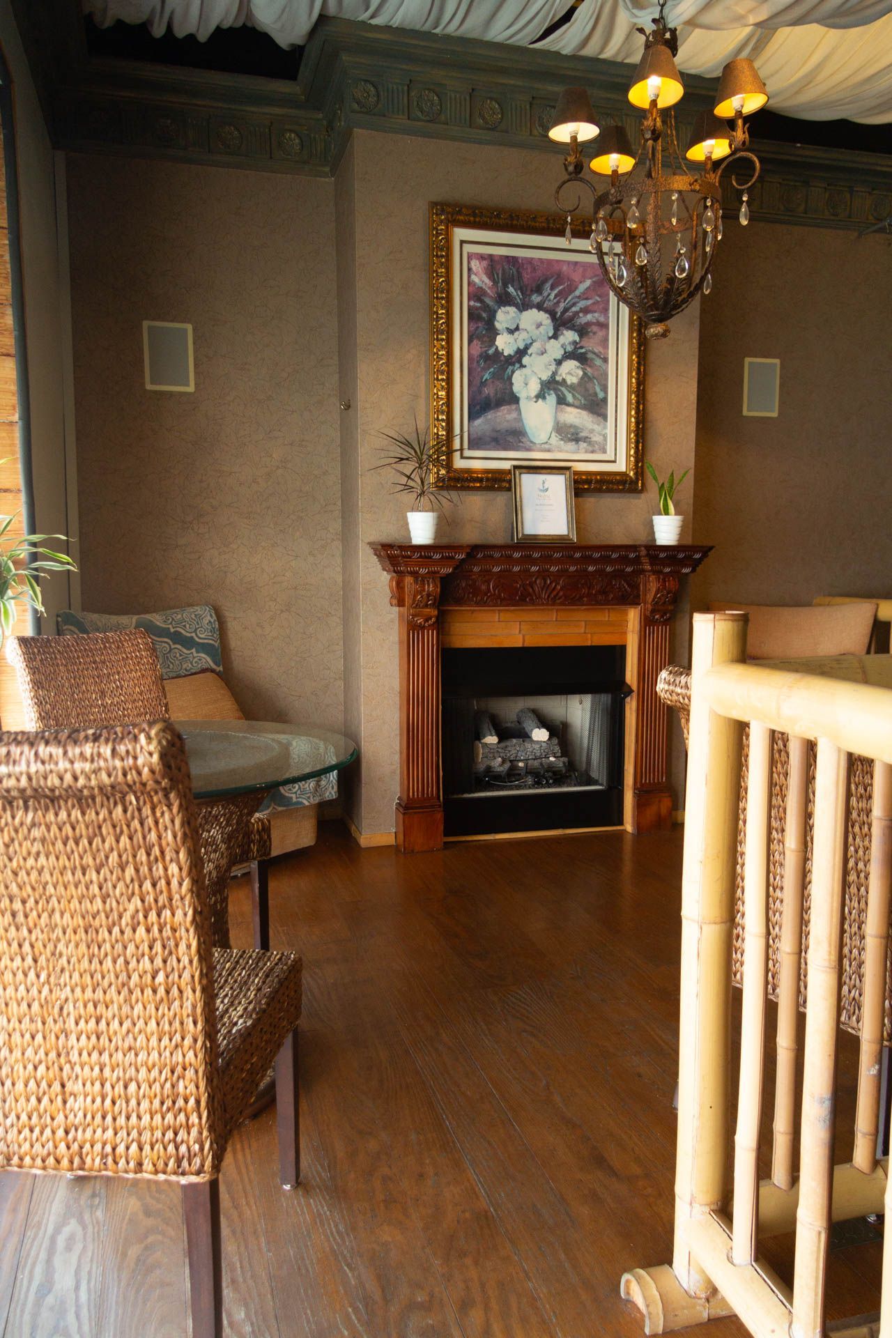 a living room with wicker chairs and a fireplace
