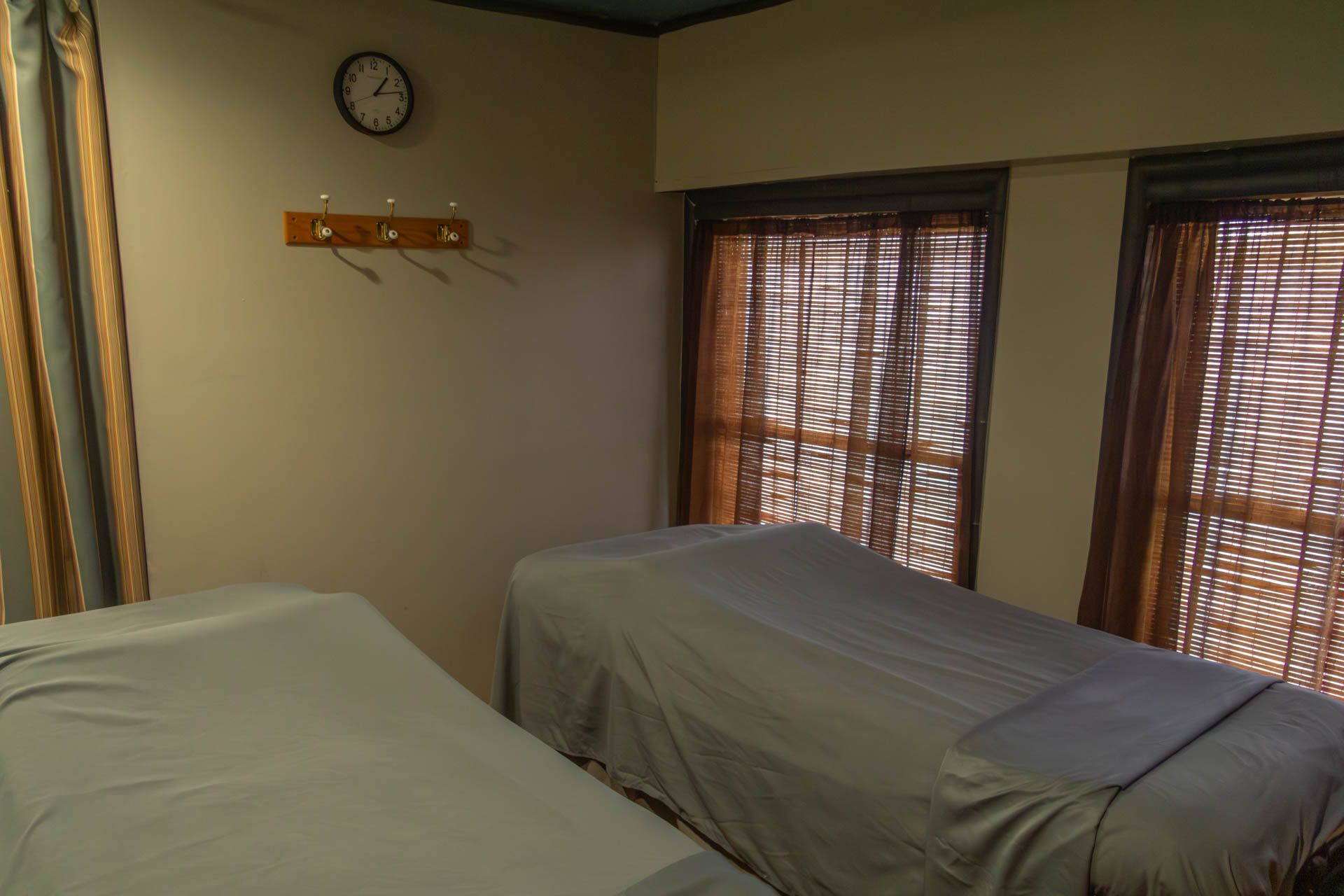 a room with two massage tables and a clock on the wall .