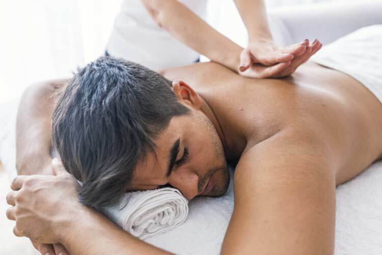 Portrait Of Man Receiving Massage Treatment From Female Hand Close-up of masseur's hands and a client's back Man getting relaxing massage in spa Man receiving back massage from masseur