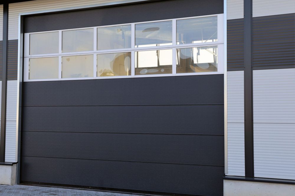 A Black Garage Door With A Lot Of Windows — Lighthouse Beach Garage Door Service in Port Macquarie, NSW