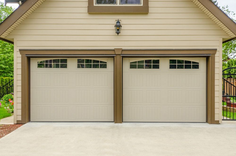 There Are Two Garage Doors On The Side Of A House — Lighthouse Beach Garage Door Service in Lake Cathie, NSW