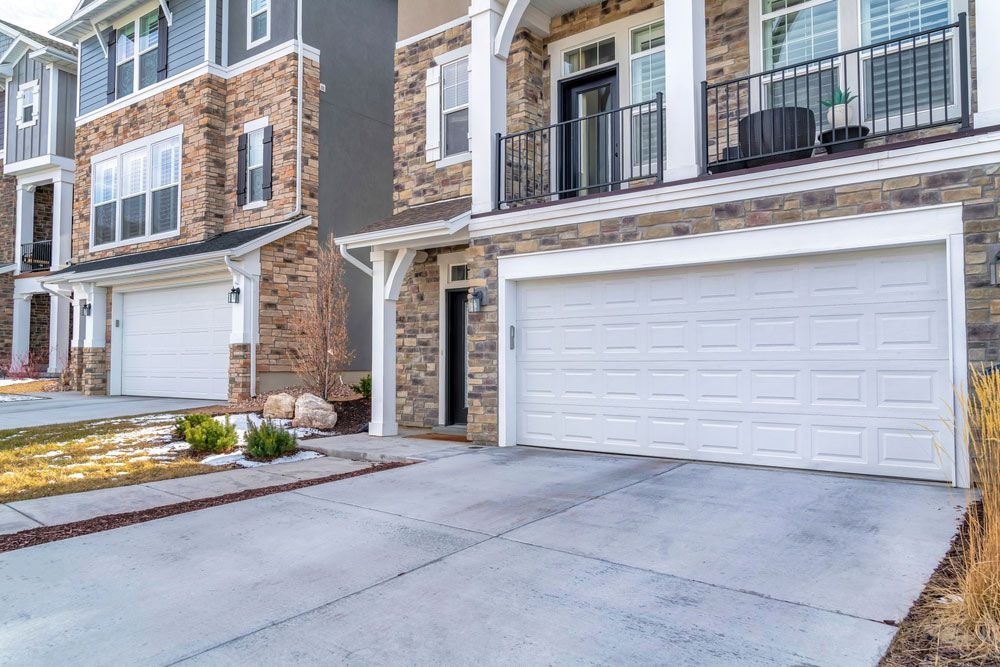 A White Garage Door Is Parked In Front Of A Brick Building — Lighthouse Beach Garage Door Service in Port Macquarie, NSW