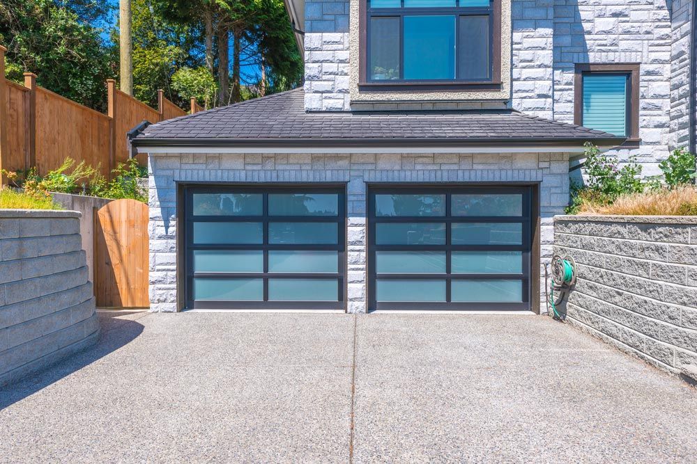 Front View Of A Large White Brick House With A Double Garage Door — Lighthouse Beach Garage Door Service in Laurieton, NSW