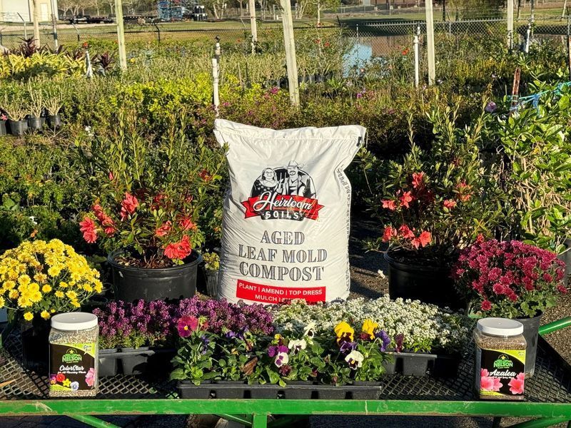 A bag of aged leaf mold compost is sitting on top of a table with flowers.