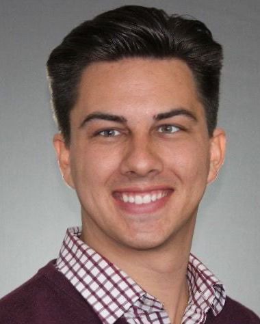 A headshot of a man with a gray background