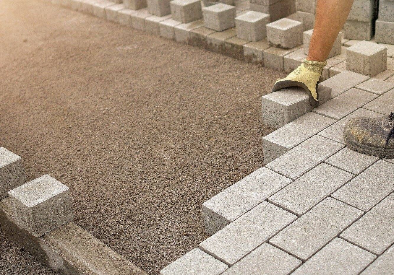Paver contractor installing pavers in a driveway
