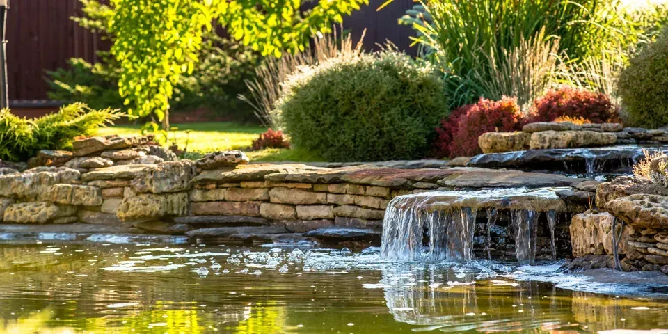 There is a waterfall in the middle of the pond.