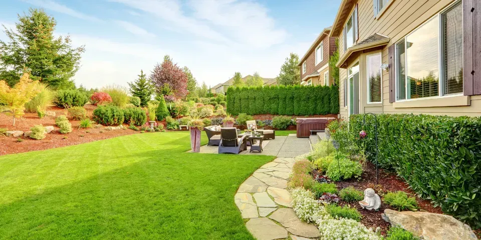 A large house with a lush green lawn and a patio.