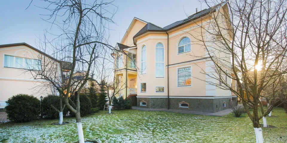 A large house with a lot of windows and trees in front of it.