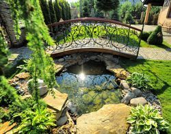 There is a bridge over a pond in the middle of the garden.
