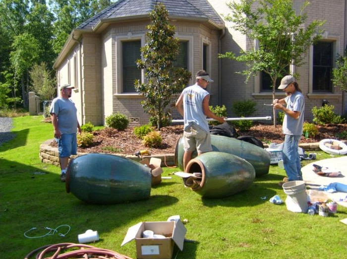 A group of men are working on a project in front of a house