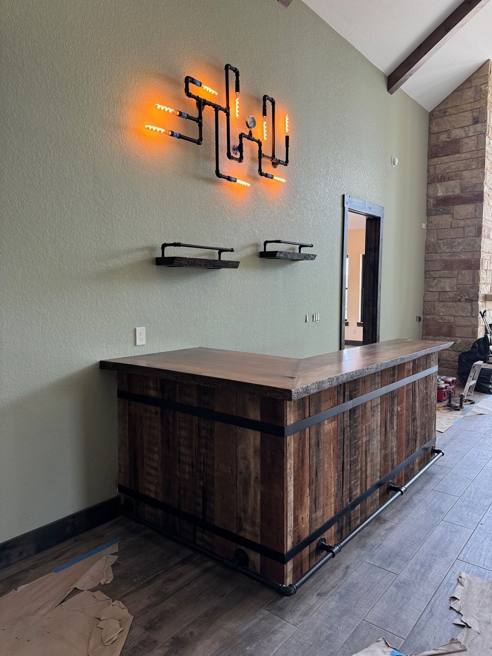 Modern reception desk with wooden front, wall sconces, and stone accent wall in a lobby