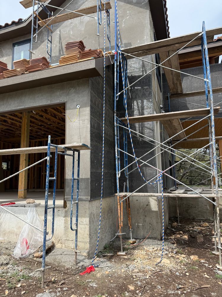 Partially built house with scaffolding and unfinished concrete walls at a construction site