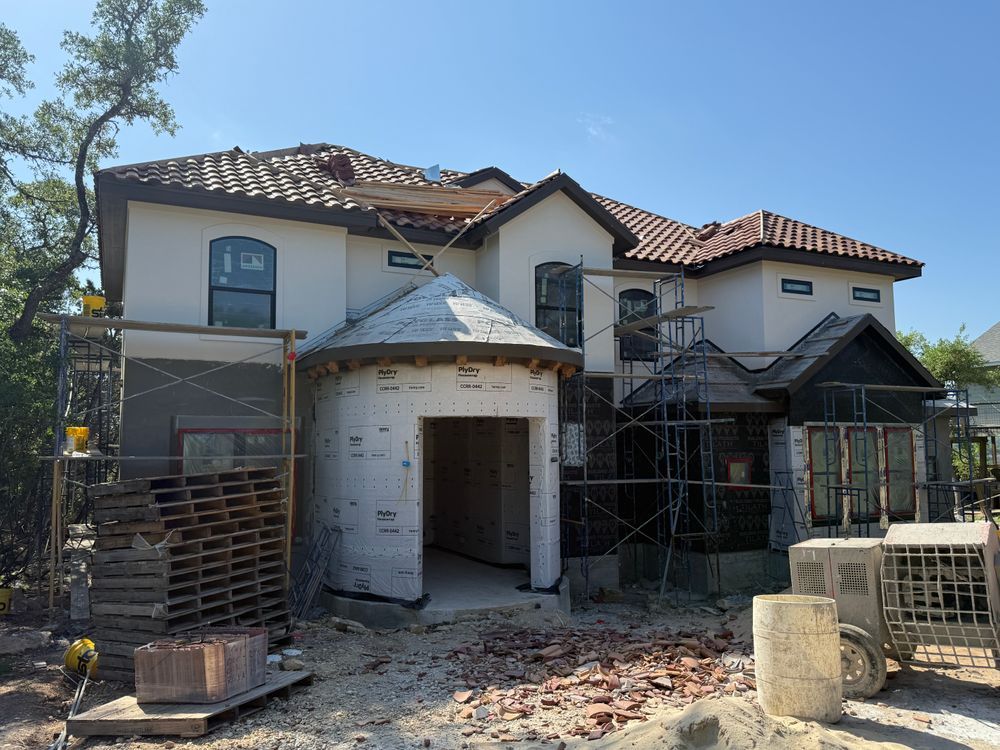 House under construction with scaffolding, exposed brick, and a damaged roof