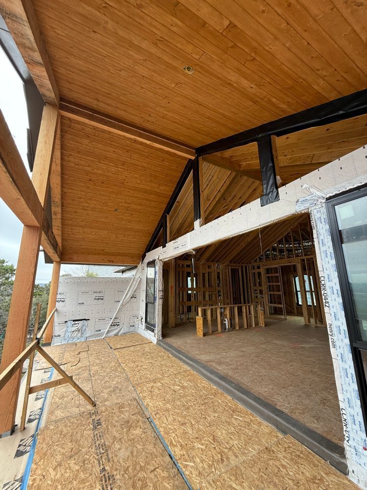 Partially built house porch with wood framing, plywood roof, and open interior under construction