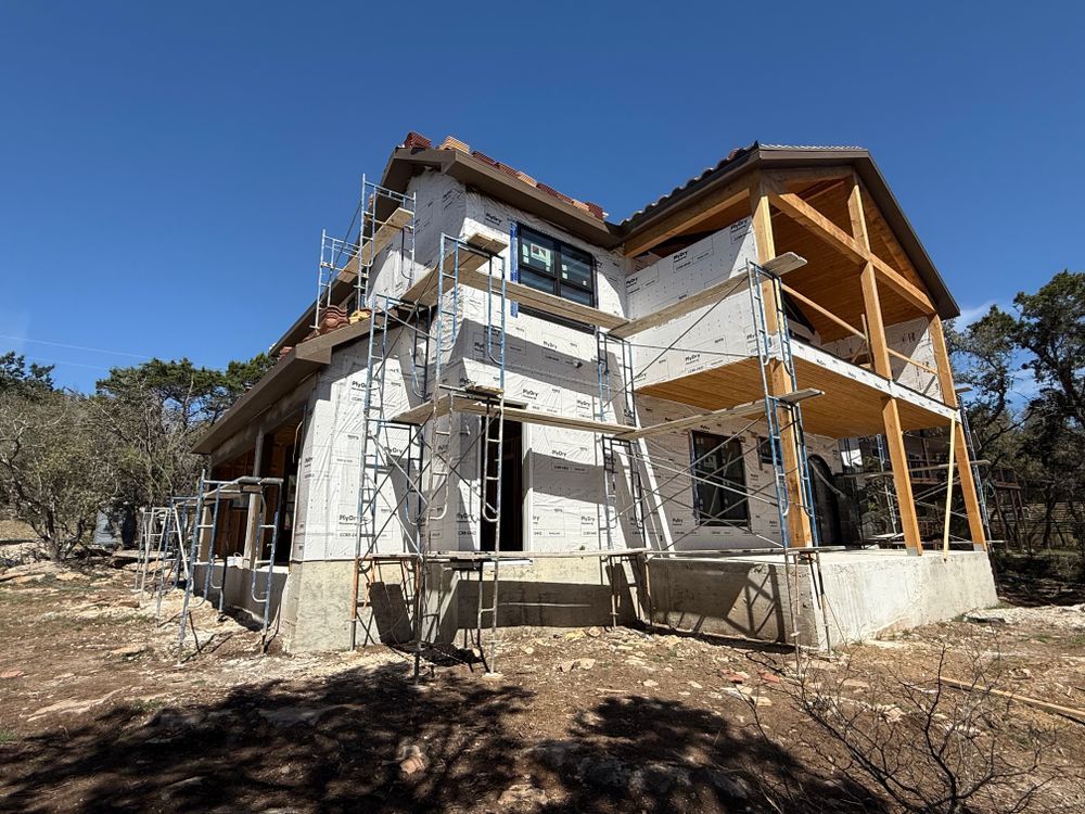 Partially constructed house with scaffolding under a clear blue sky