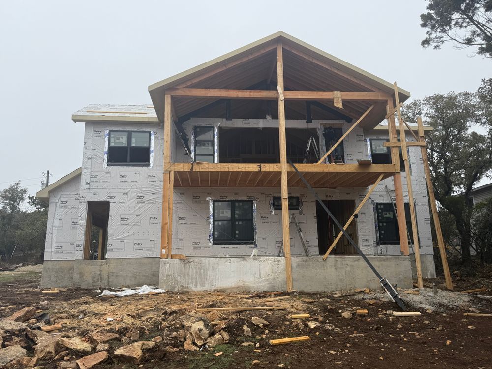 Partially built two-story house with exposed wood framing and unfinished exterior walls