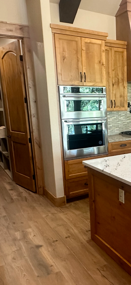 Kitchen with wood cabinets, built-in stainless oven, and granite countertop in a home interior