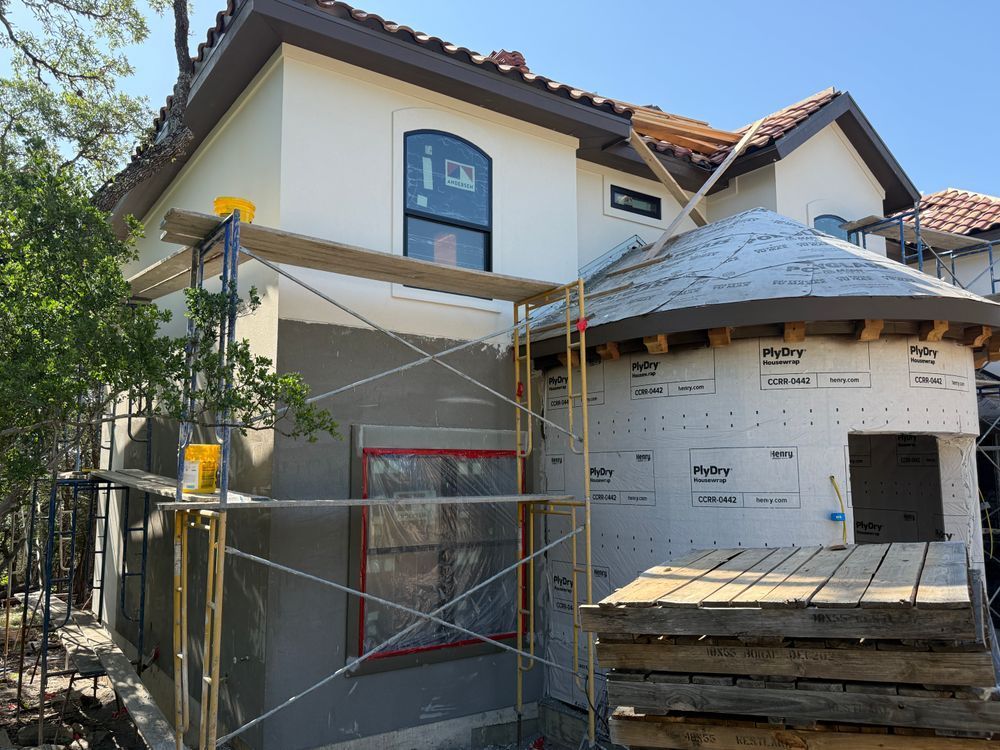 House exterior under construction with scaffolding and wrapped porch area